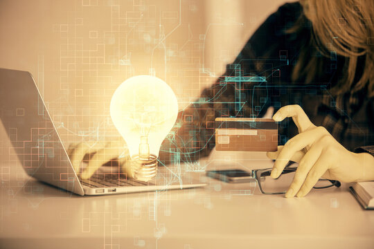 Multi exposure of woman on-line shopping holding a credit card and bulb drawing. Choice concept.