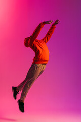 African man jumping high isolated over pink neon background