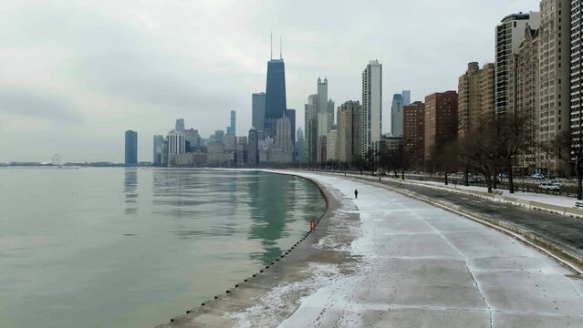 People walking on the Concrete Beach under tall buildings of Gold Coast, Chicago, USA - Aerial view