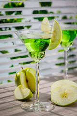 Appletini cocktail, apple martini cocktail garnished with green apple. Martini alcoholic cocktail or non-alcoholic mocktail. Martinis.