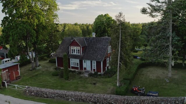 Beautiful country house aerial. Drone flies backwards to reveal the greenery and fields surrounding the house. Country living concept.