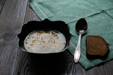 Appetizing traditional Russian dish Shchi - sour cabbage soup served in bowl, on a wooden table.