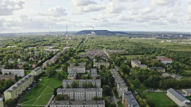 Industrial landscape aerial. Camera flies above Post-Soviet town with industrial polluting factory in the background.