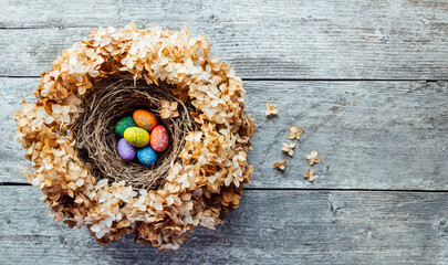 Easter eggs in a nest on a wooden background. High quality photo. nest of dried flowers. place for teekst, banner