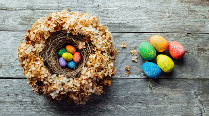 Easter eggs in a nest on a wooden background. High quality photo. nest of dried flowers. place for teekst, banner