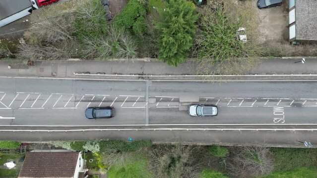 Vehicles slowly driving around  large pothole UK croad overhead birds eye view drone aerial