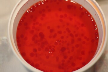 Bright red liquid in a white bowl.