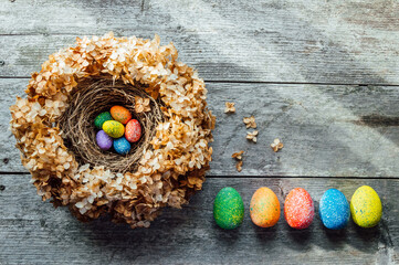 Easter eggs in a nest on a wooden background. High quality photo. nest of dried flowers. place for teekst, banner