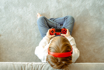 Little boy playing video game console using joystick or controller while sitting at home real people family leisure concept © Danko