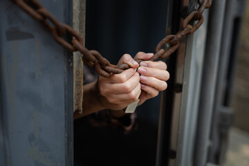 woman's hand trapped in an illegally smuggled container locked with chain and key. Efforts to...
