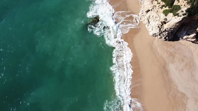 Aerial drone view of a deserted beach with many waves on the Costa Brava, Catalonia, Spain.