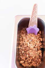 Close up photo of a metal tray filled with muesli toppings on an ice cream parlor counter