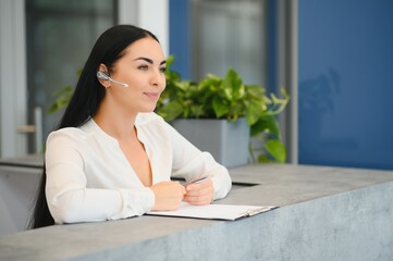 Portrait of beautiful receptionist near counter in hotel