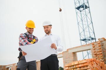 Structural engineer and foreman worker discuss, plan working for the outdoors building construction...