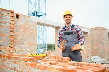 Construction worker man in work clothes and a construction helmet. Portrait of positive male...