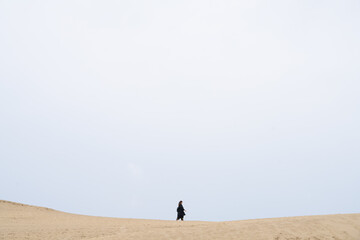 Fototapeta na wymiar 砂丘を歩く女性