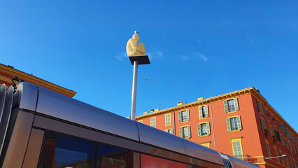 Red facades, blue sky, sculpture as a visiting card in Nice in the south of France. Views and architecture of the Cote d'Azur	
