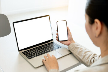 computer screen,cell phone blank mockup.hand woman work using laptop texting mobile.white...