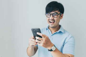 adult asian man using mobile, cell phone.young male person.posing smiling laughing look excited surprised thinking positive happy.empty,copy space for text advertising.white background