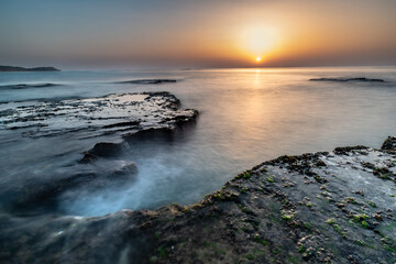Sunset over rocky seashore Palmachim beach Israel