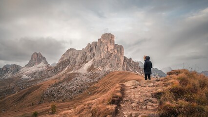 Woman enjoying the top of the mountain, overlooking a snowy range, Dolomites Italy