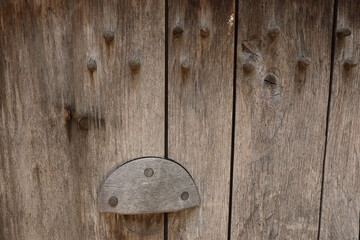 A close-up of an old wooden door and its door handle
