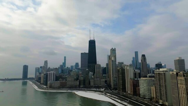 Drone shot around the lakeside cityscape of the Near North Side, in mostly cloudy Chicago, USA