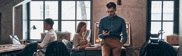 Group of young people working in the office together