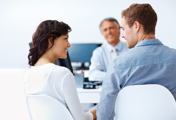 Couple discussing financial plan with advisor. Happy couple discussing financial plan in office...