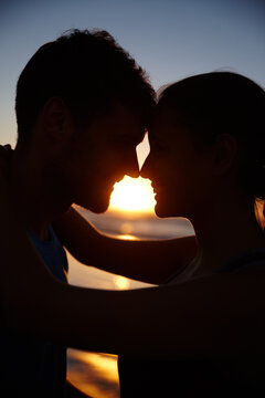 Start the day with romance. Closeup image of a romantic couple silhouetted against the sunrise.