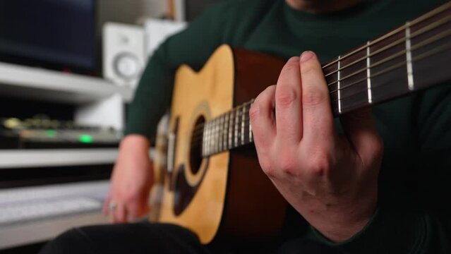 man practicing on an acoustic guitar, closeup indoors. High quality 4k footage