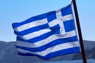 Flag of Greece on a sunny day over the sea