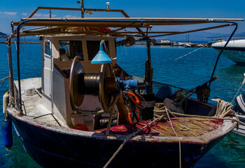 Fototapeta premium Small fishing boat with fishing equipment anchored in calm waters.
