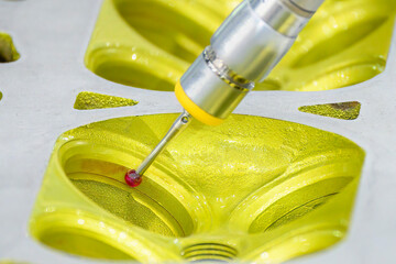 The CMM machine measuring the aluminum cylinder head parts .