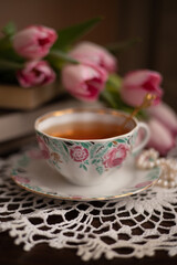 Photo of a cup of tea with a bouquet of flowers.