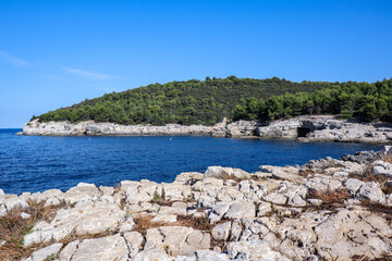 Fototapeta na wymiar Summer Scenery with Adriatic Sea in Croatia. Istrian Peninsula with Rocky Bay and Blue Sky in Pula. 