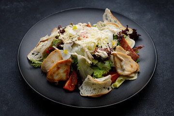 Caesar salad with chicken, on dark concrete