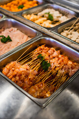Selective focus on plenty choices of meat in pots for traditional charcoal grill BBQ style in all you can eat buffet.