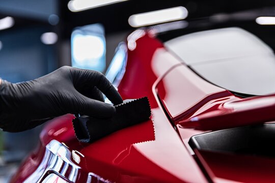Application of ceramic coating in car detailing studio or car wash. Beautiful red car paint.