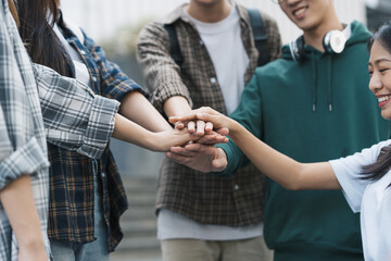 Group of happy multiethnic colleagues shaking hands Express joy in the creative team. Friends or students in project meetings at modern university startups or teamwork concepts.