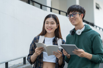 Two Asian students studied and researched together with laptop computers and journaling in an outdoor biological analogy at university.