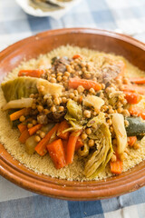 Traditional Moroccan Couscous dish on a squared blue tablecloth ambient. 