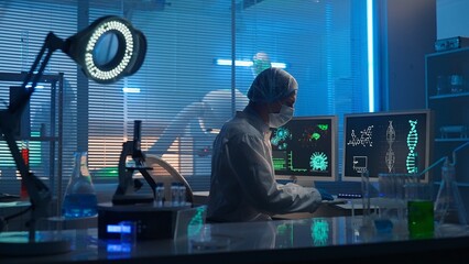 Medical development laboratory. A male scientist types on a keyboard and enters research data. A...