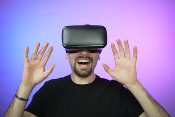Young man is fully immersed in a virtual reality experience, wearing cutting-edge VR glasses...
