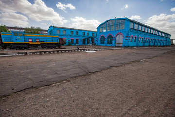 Kazaly, Kazakhstan - May 02, 2012: Locomotive repair plant and depot main building. Diesel loco left.