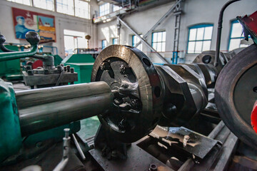 Kazaly, Kazakhstan - May 02, 2012: Restoring locomotive engine crankshaft on lathe closeup photo. Low depth of field.