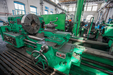 Kazaly, Kazakhstan - May 02, 2012: Old vintage Soviet turning machine. operator on background. Interior of locomotive repair plant (depot).