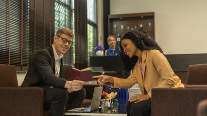 Two business workers or a couple travelers are waiting and taking facility service at an exclusive airline lounge. Travelers get refreshment at a private lobby to be ready for their trip.