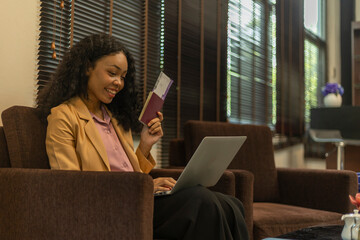 Female business traveler using airport lounge or lobby to prepare for her trip. Business woman is...