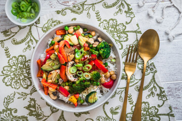 Bowl with rice and vegetables on white wooden table, vegetarian, vegan, healthy food, top view